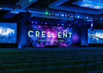 AV production setup at a corporate tech summit in Charlotte, NC, featuring stage lighting, screens, and seamless audio by Crescent Event Productions.